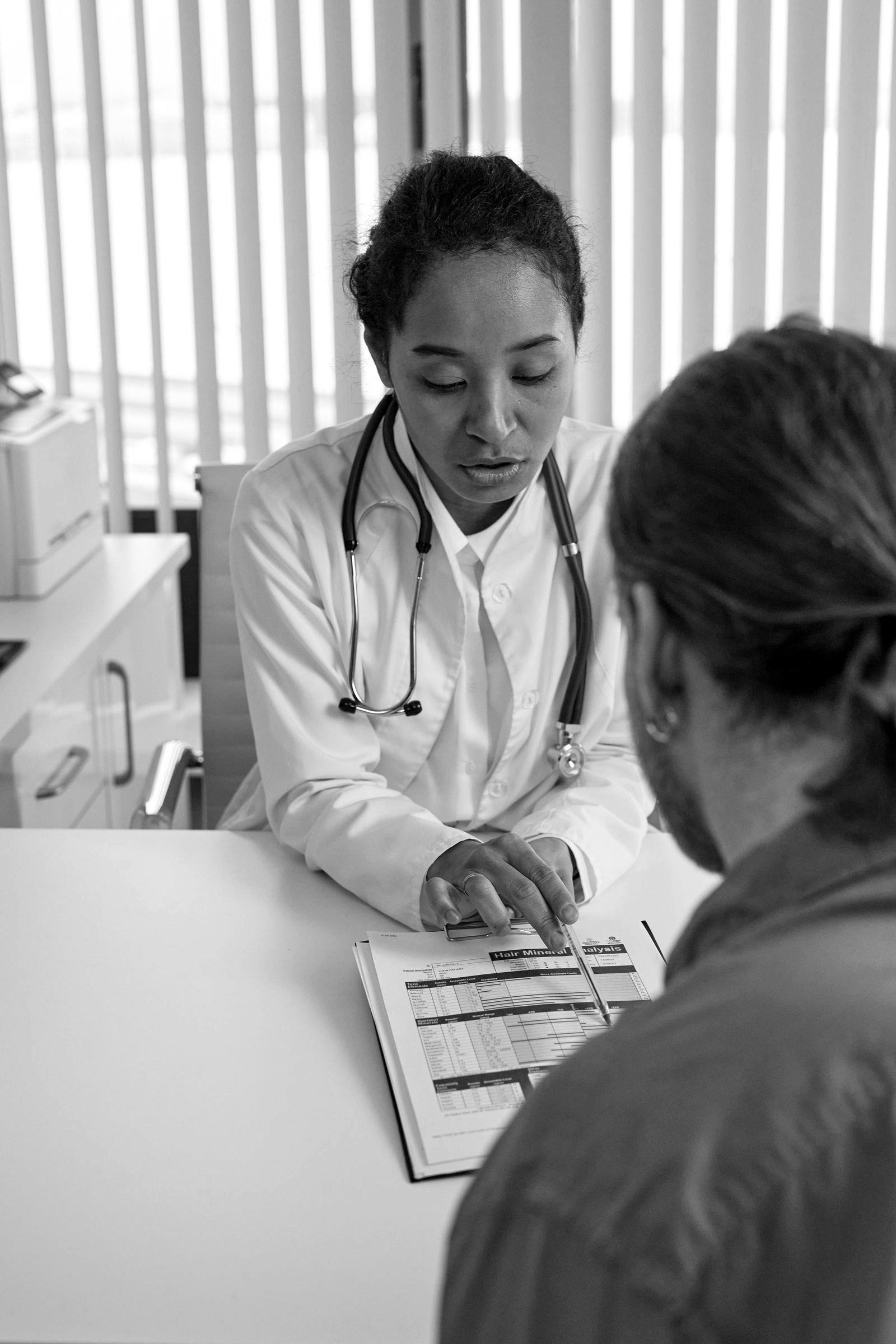 A clinician reviewing medical records with a patient during a consultation
